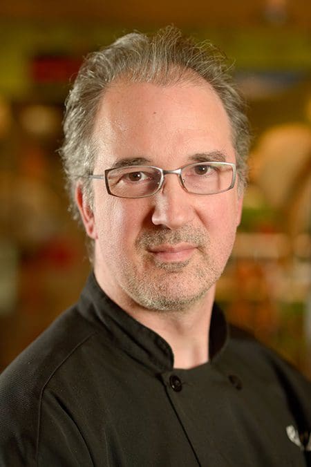 A man with glasses and a beard wearing black.