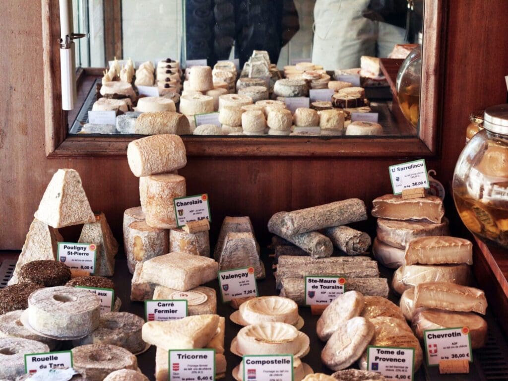 A bunch of cheese on display at an outdoor market