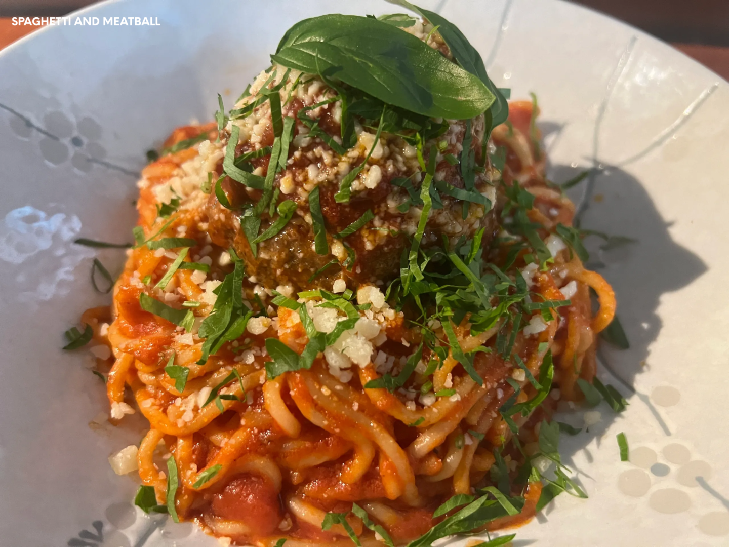 A plate of pasta with sauce and basil.