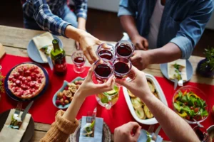 A group of people holding wine glasses at a table.