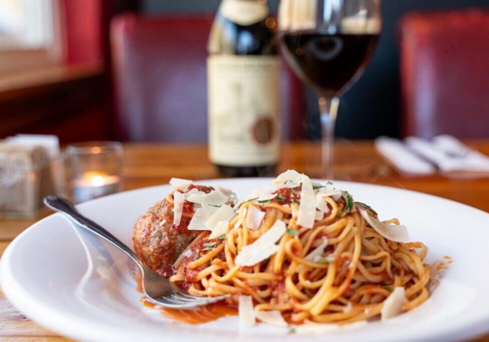 A plate of spaghetti and meatballs on top of a table.